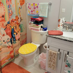 yellow lace toilet lid cover in colorful bathroom